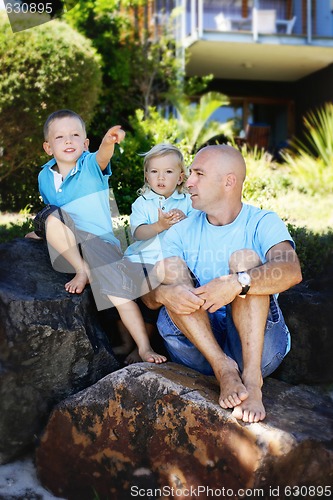 Image of Father and sons together outdoors.