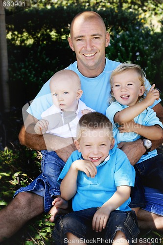 Image of Father and sons together outdoors.