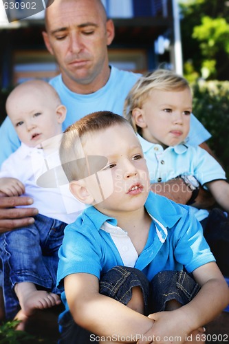 Image of Father and sons together outdoors.