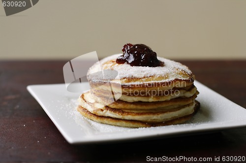 Image of Stack of pancakes with honey and jam.