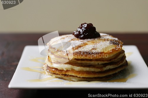 Image of Stack of pancakes with honey and jam.