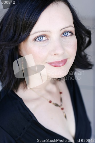 Image of Portrait of a beautiful woman with blue eyes wearing a black out