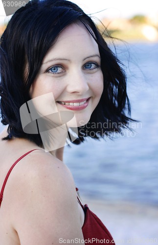 Image of Portrait of a beautiful happy woman in a red dress outdoors.