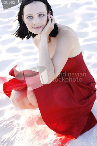 Image of Portrait of a beautiful woman in a red dress outdoors.
