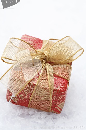 Image of Christmas gift with red wrapping and decorative bow.