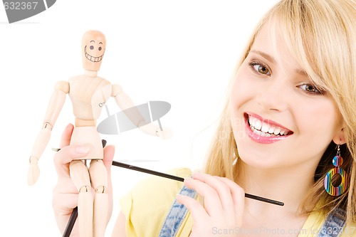 Image of happy teenage girl with wooden model dummy