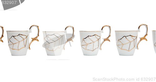 Image of Row of white coffee cups with golden leaf isolated 