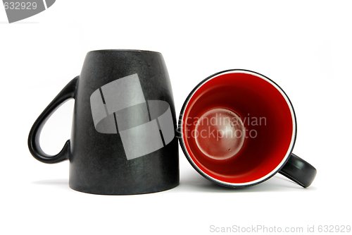 Image of Two black coffee cups down and on side isolated