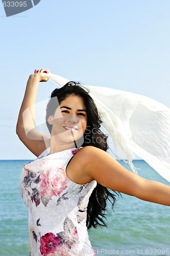 Image of Beautiful young woman at beach with white scarf