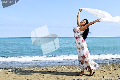 Image of Beautiful young woman at beach with white scarf