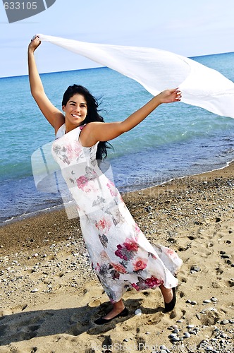 Image of Beautiful young woman at beach with white scarf