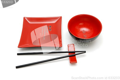 Image of Square red plate, round bowl and chopsticks on stand isolated