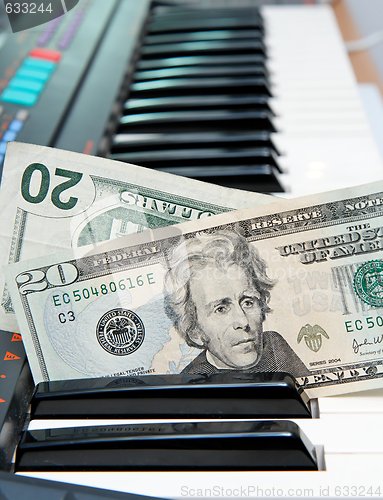 Image of Two twenty dollar bills stuck in electric organ keyboard