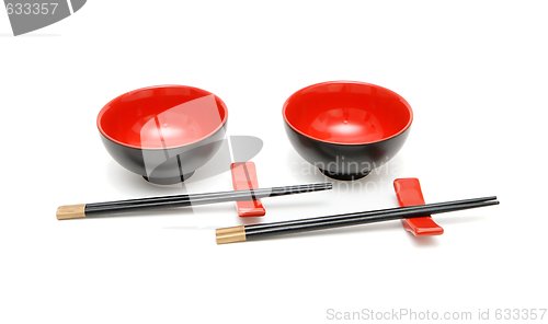 Image of wo sets of chopsticks and red and black Japanese bowls isolated