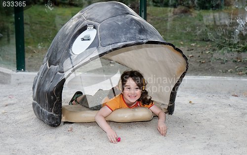 Image of Cute little girl lies in the turtle shell