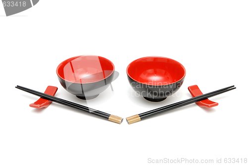 Image of Two sets of chopsticks and red and black Japanese bowls isolated 