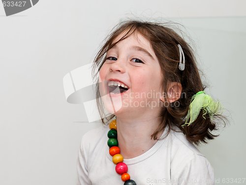 Image of Laughing girl in white shirt with colored beads