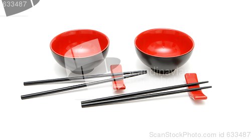 Image of Two sets of chopsticks and red and black Japanese bowls isolated