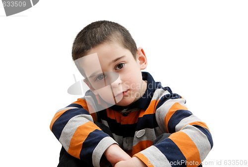 Image of Serious cute little five year old boy sits  isolated