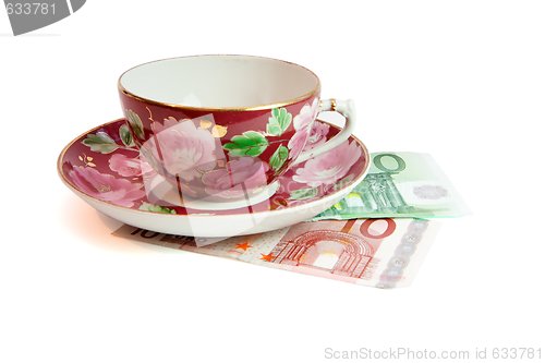 Image of Tea service stands on euro banknotes isolated 