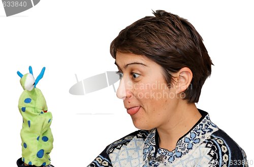 Image of Woman sticks out her tongue to a glove puppet isolated