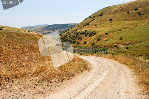 Image of Countryside road bends among yellow autumn hills 