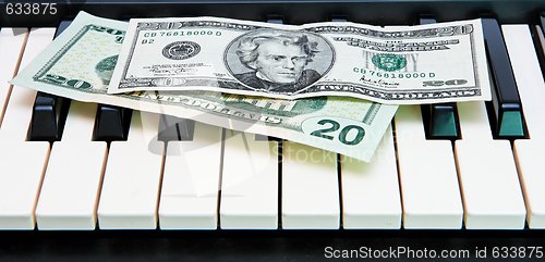 Image of Two twenty dollar bills on electric organ keyboard