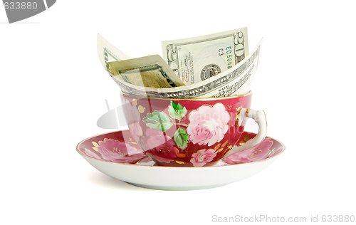 Image of Tea cup with twenty dollar bills sticking out isolated 