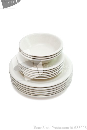 Image of Stack of plain beige dinner and soup plates and saucers isolated