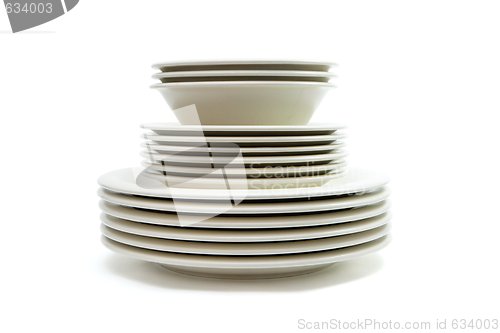Image of Stack of plain beige dinner and soup plates and saucers isolated