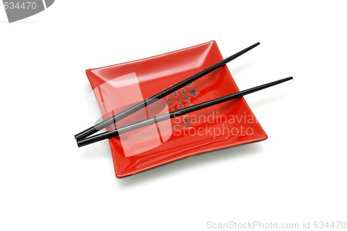 Image of Chopsticks on red square plate with kanji inscription isolated