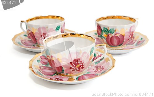 Image of Three floral-painted tea cups with saucers isolated 