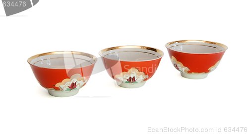 Image of Three red porcelain drinking bowls isolated 