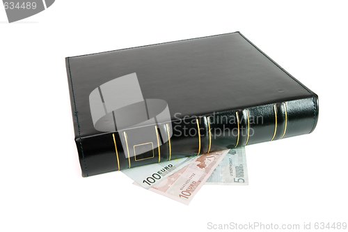 Image of Thick black book on euro bills isolated