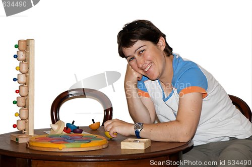 Image of Smiling woman plays with wooden toys isolated