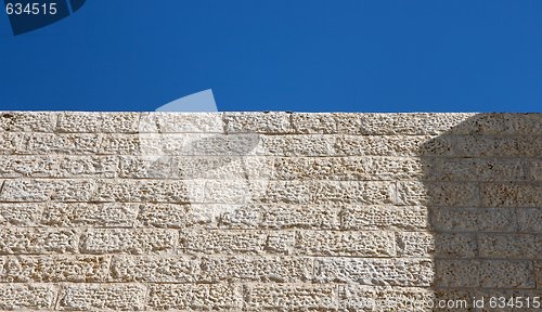 Image of Beige rough stone wall and blue sky texture