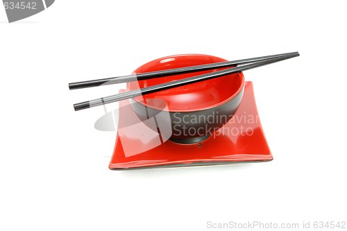 Image of Chopsticks on red and black oriental bowl and square plate isolated