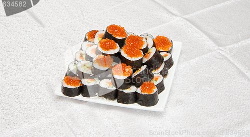 Image of Homemade sushi with red caviar on white square plate 