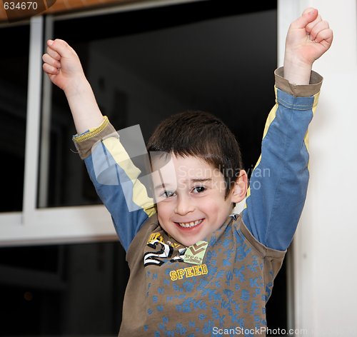 Image of Cute little boy rises his arms in a V-sign