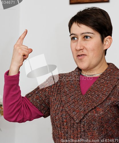 Image of Young short-haired woman raising her finger