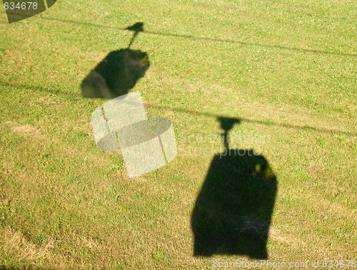 Image of Shadows of cable cars on the grass