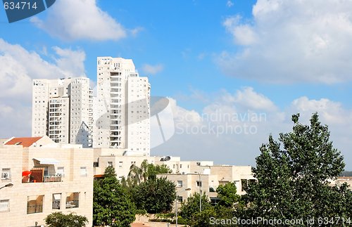Image of New white apartment buildings under blue cloudy sky