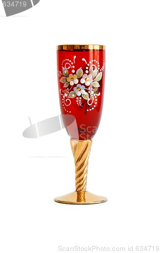 Image of Beautiful red wine glass with flower pattern and a golden stem isolated