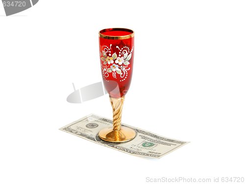 Image of Beautiful red wine glass  with golden stem on twenty dollar bill isolated