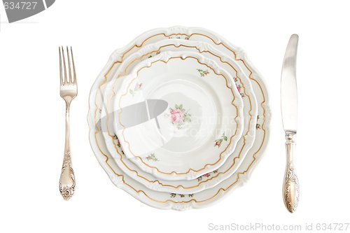 Image of Dinner set with three plates, knife and fork isolated