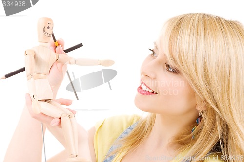 Image of happy teenage girl with wooden model dummy