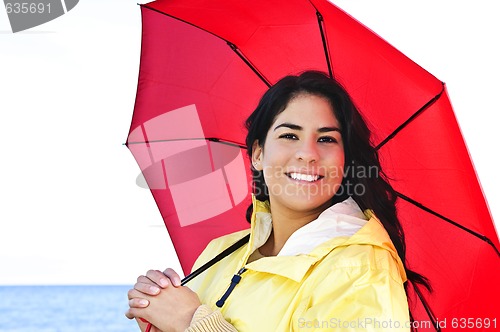 Image of Beautiful young woman in raincoat with umbrella