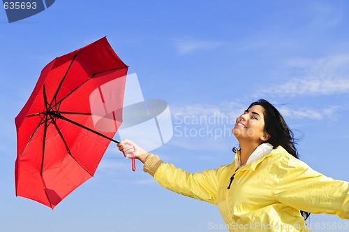 Image of Beautiful young woman in raincoat with umbrella