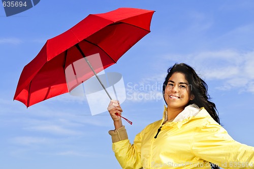 Image of Beautiful young woman in raincoat with umbrella