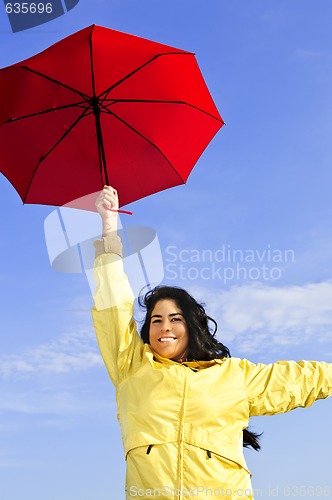 Image of Beautiful young woman in raincoat with umbrella